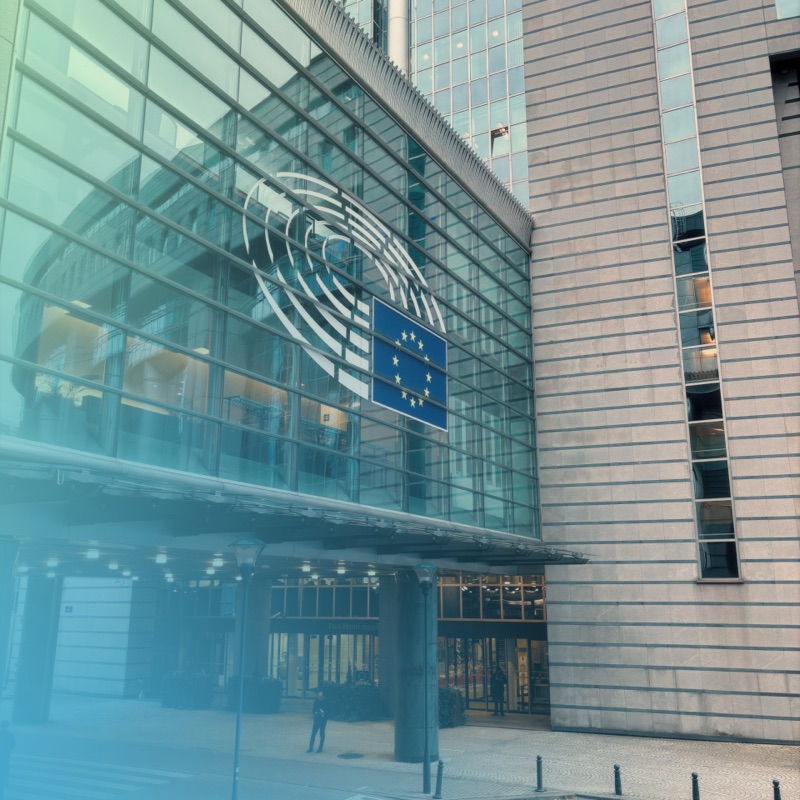 Entrance of the European Parliament building in Brussels with the EU flag